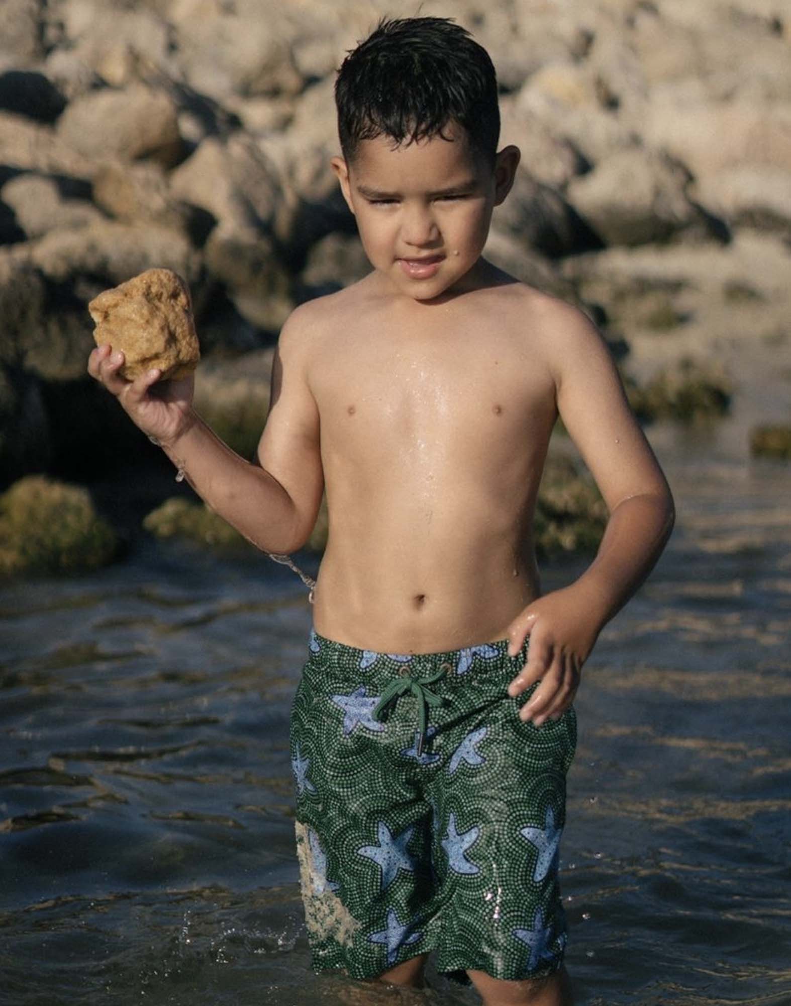 SevenC's Kids' Recycled Polyester Shorts in Star Fish Print on model at beach
